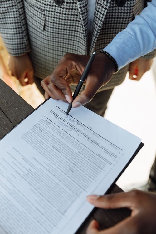 Close-up of a person reviewing and signing a document