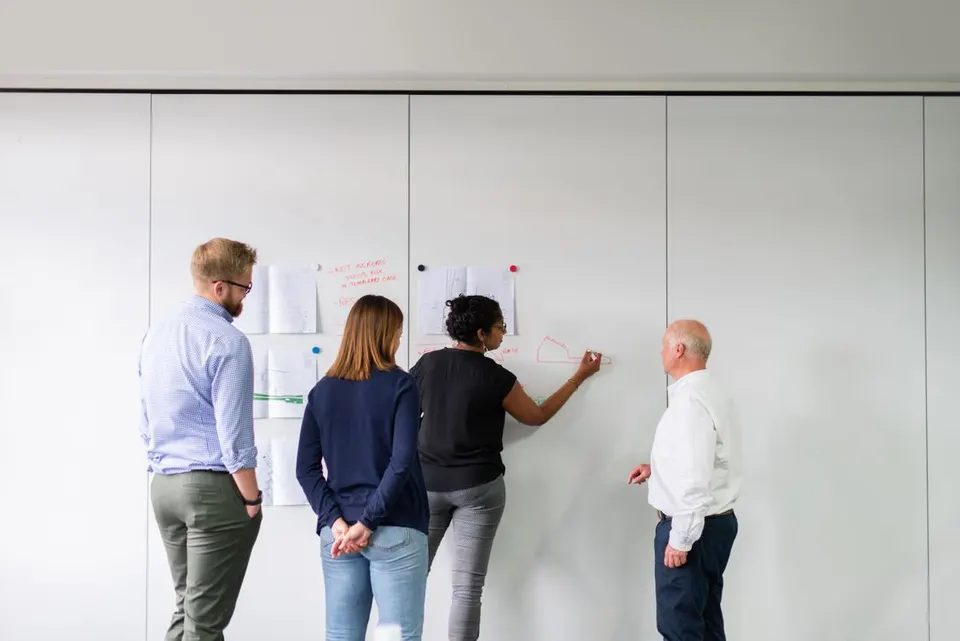Team reviewing a plan at a whiteboard