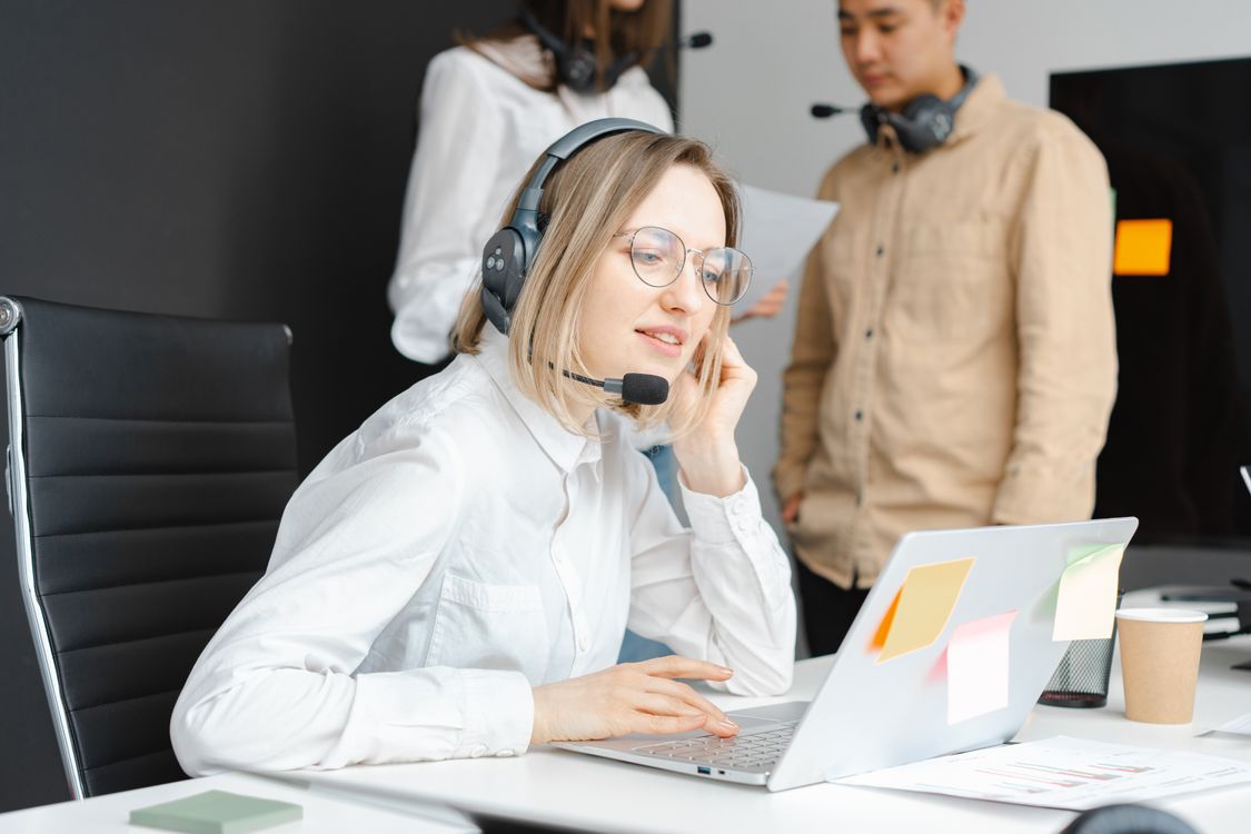Support professional wearing a headset while working at a laptop