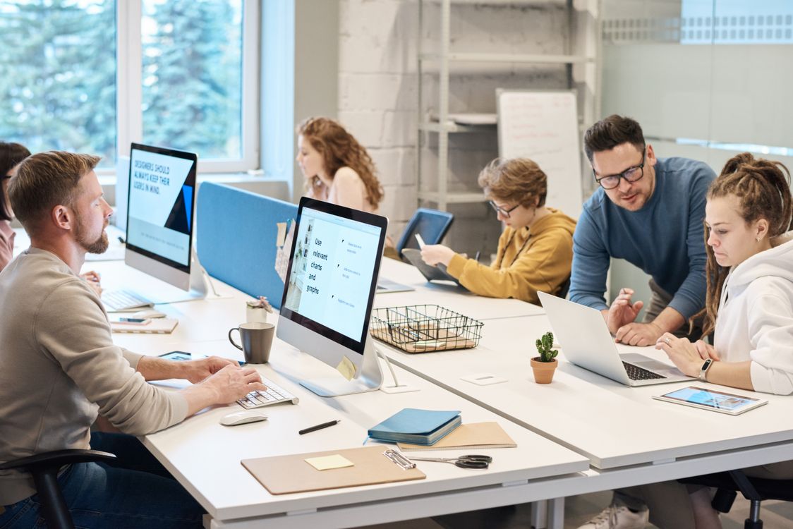 Colleagues working together at computers in a shared office